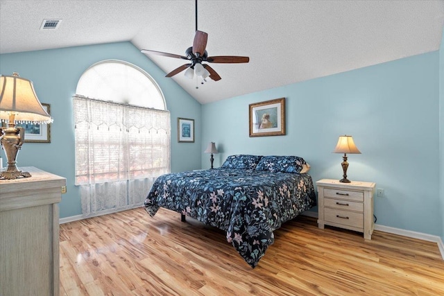 bedroom featuring vaulted ceiling, wood finished floors, visible vents, and baseboards