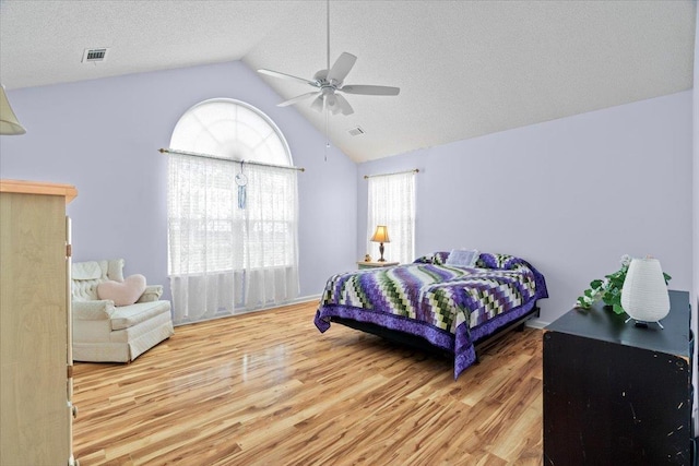 bedroom featuring high vaulted ceiling, a ceiling fan, wood finished floors, and visible vents