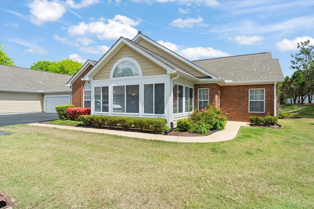 back of house with brick siding, a yard, a shingled roof, and a garage