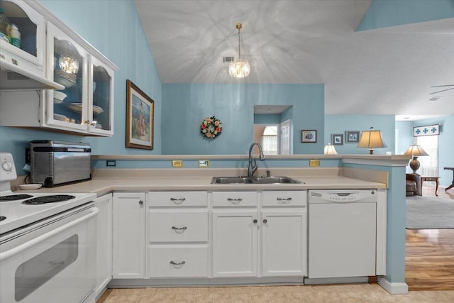 kitchen with plenty of natural light, a peninsula, white appliances, and a sink