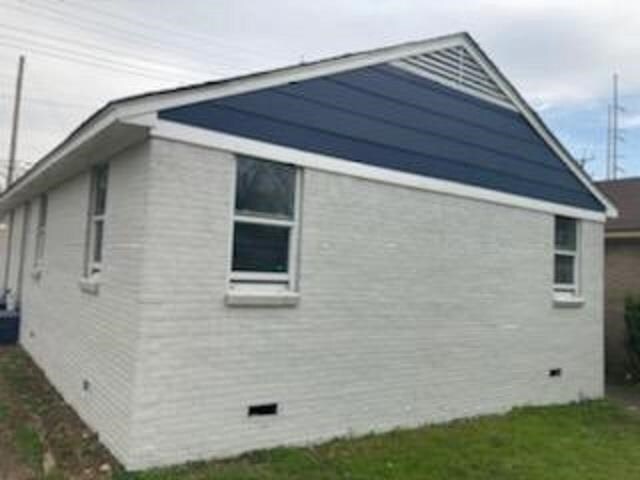 view of property exterior with brick siding and crawl space