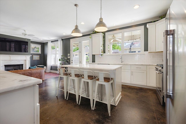 2363 Autumn Ave, Memphis, TN 38112 - kitchen featuring stainless steel range with gas cooktop, decorative backsplash, finished concrete floors, and ceiling fan
