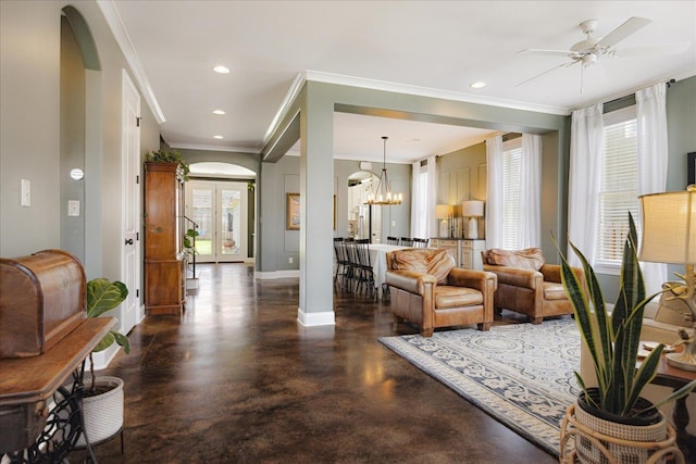 2363 Autumn Ave, Memphis, TN 38112 - living room with arched walkways, concrete flooring, crown molding, baseboards, and ceiling fan with notable chandelier