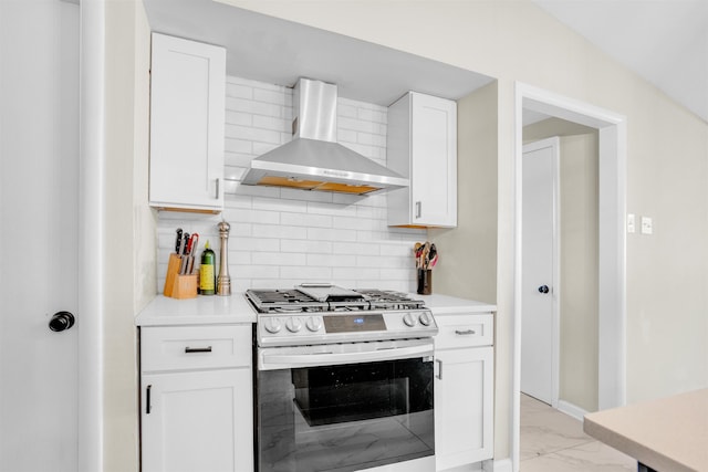 5657 Walnut Grove Rd, Memphis, TN 38120 - kitchen featuring gas range, marble finish floor, wall chimney exhaust hood, and white cabinetry