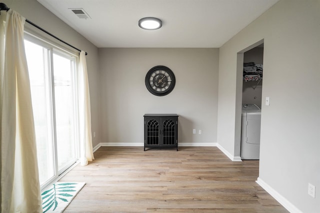 unfurnished dining area with plenty of natural light, visible vents, light wood finished floors, and washer / clothes dryer