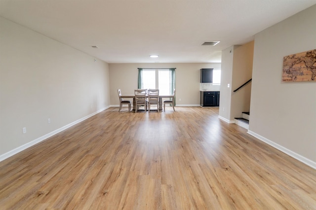 dining area featuring baseboards, stairs, visible vents, and light wood-style flooring