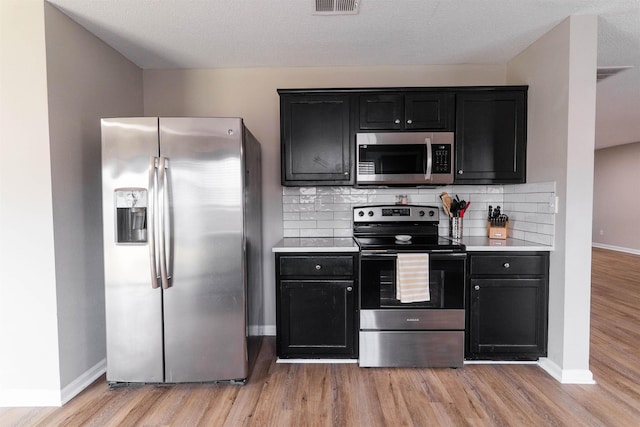 kitchen featuring light wood-type flooring, baseboards, and stainless steel appliances