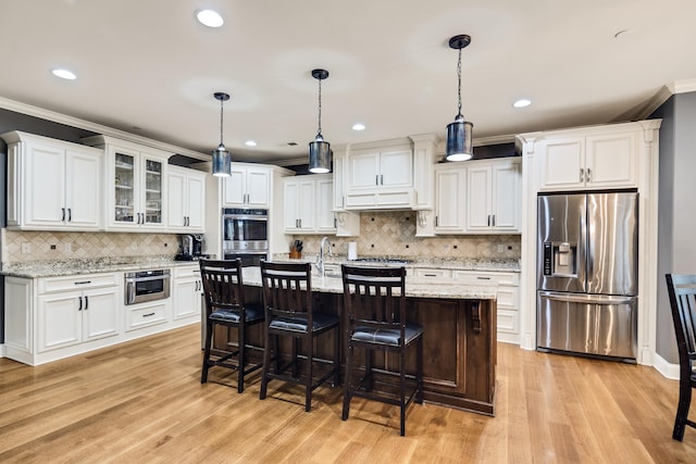 250 Ridgewood Dr, Piperton, TN 38017 - kitchen with light wood finished floors, stainless steel appliances, white cabinetry, and ornamental molding