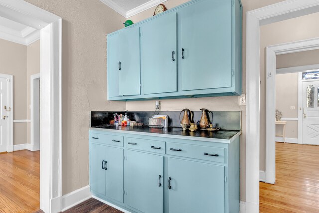 bar with baseboards, crown molding, and wood finished floors