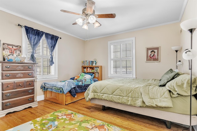 bedroom featuring baseboards, light wood-style floors, ceiling fan, and crown molding