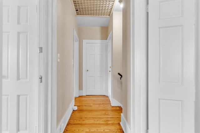 hall featuring baseboards and light wood finished floors
