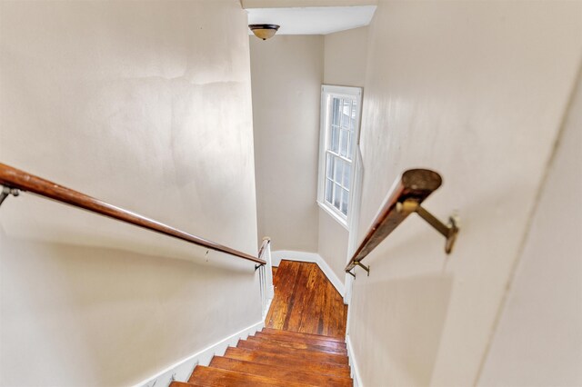 stairway with baseboards and wood finished floors