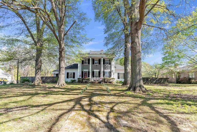 rear view of house featuring fence and a yard