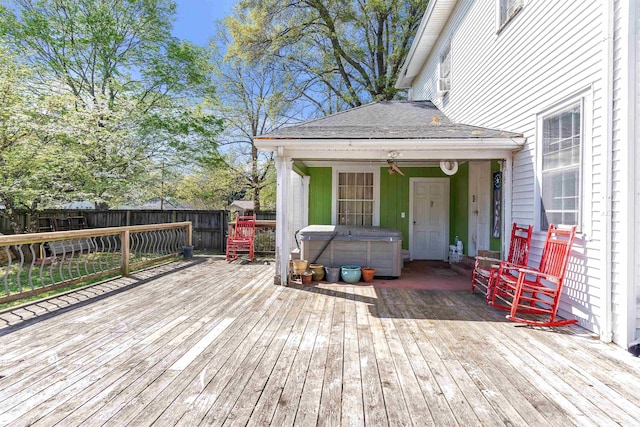 wooden terrace featuring a hot tub and a fenced backyard