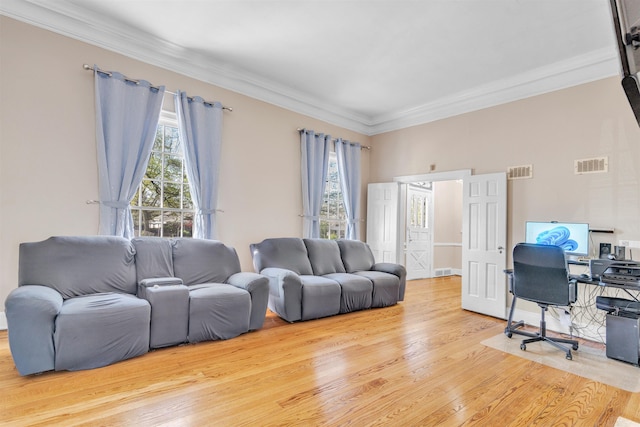 living room with wood finished floors, visible vents, and crown molding