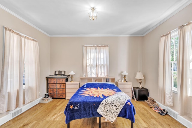 bedroom featuring visible vents, wood finished floors, and ornamental molding