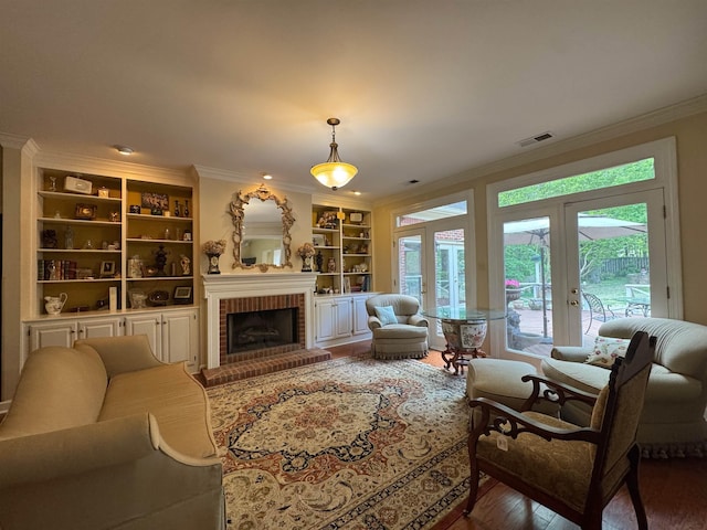 living area featuring built in features, a wealth of natural light, and ornamental molding