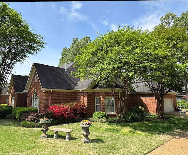 view of front of house with brick siding, roof with shingles, a front lawn, and a garage