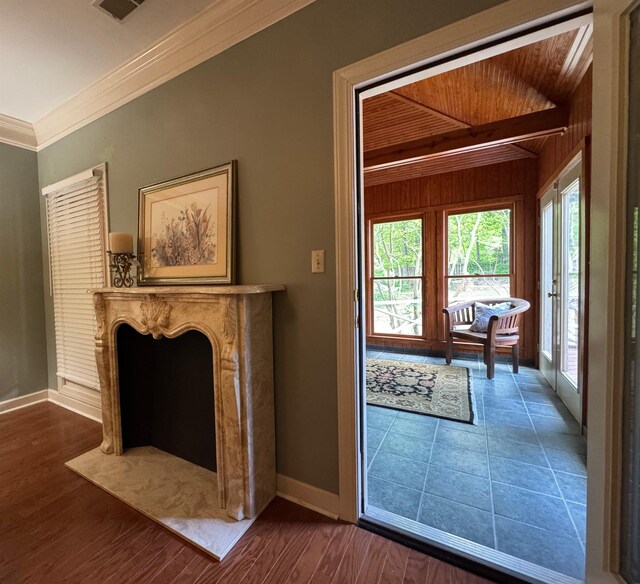entryway featuring wood walls, visible vents, wooden ceiling, ornamental molding, and baseboards