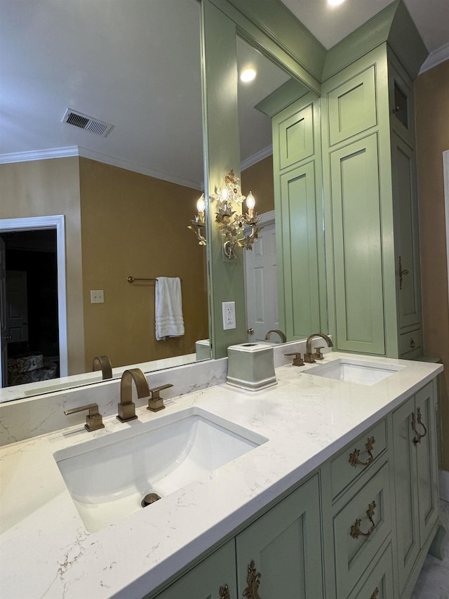 bathroom with crown molding, a sink, and visible vents