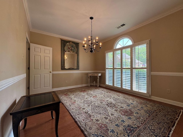 unfurnished dining area with wood finished floors, visible vents, ornamental molding, baseboards, and a notable chandelier
