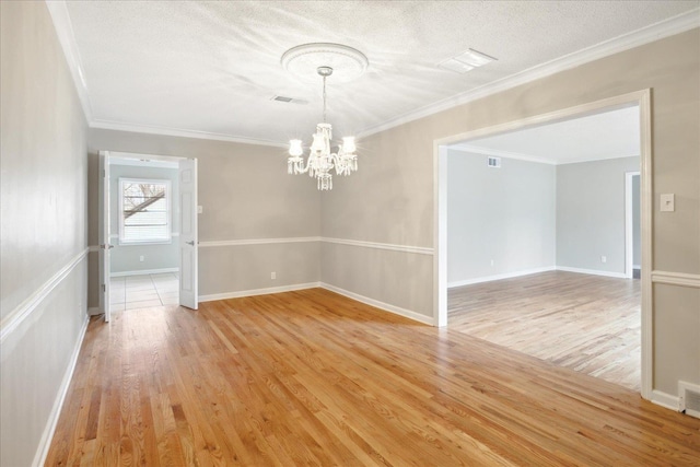 5676 Walnut Grove Pl, Memphis, TN 38120 - unfurnished dining area with light wood-style flooring, an inviting chandelier, a textured ceiling, and ornamental molding