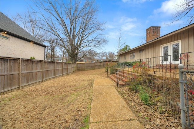 5676 Walnut Grove Pl, Memphis, TN 38120 - view of yard featuring french doors, a garden, and a fenced backyard