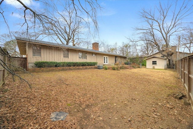5676 Walnut Grove Pl, Memphis, TN 38120 - rear view of property featuring an outbuilding, a fenced backyard, central air condition unit, a chimney, and board and batten siding