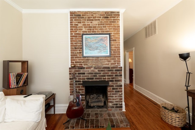 544 Summitt St, Memphis, TN 38104 - living area with wood finished floors, visible vents, ornamental molding, and a brick fireplace