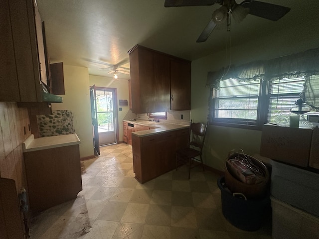 kitchen with a peninsula, a ceiling fan, light countertops, and plenty of natural light