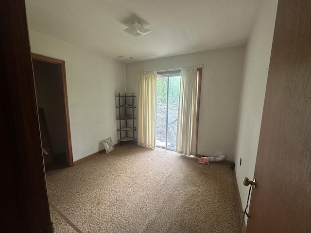 spare room with baseboards and carpet