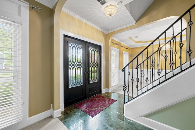 entrance foyer with arched walkways, crown molding, french doors, and baseboards