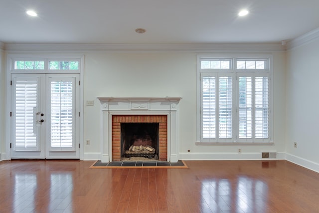 unfurnished living room featuring a fireplace, wood finished floors, visible vents, and baseboards