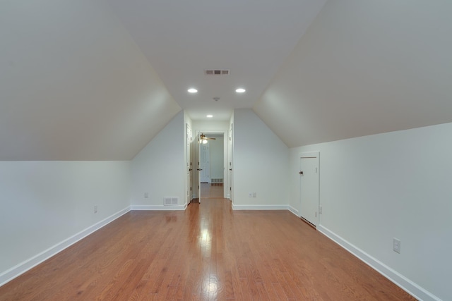 bonus room with baseboards, wood finished floors, and visible vents