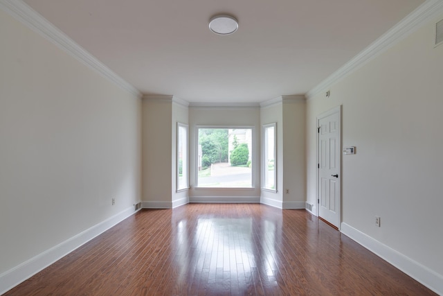 spare room featuring visible vents, baseboards, dark wood-style floors, and ornamental molding
