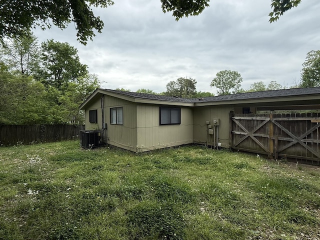 4279 University St, Memphis, TN 38127 - view of side of home with a lawn, central AC unit, and fence