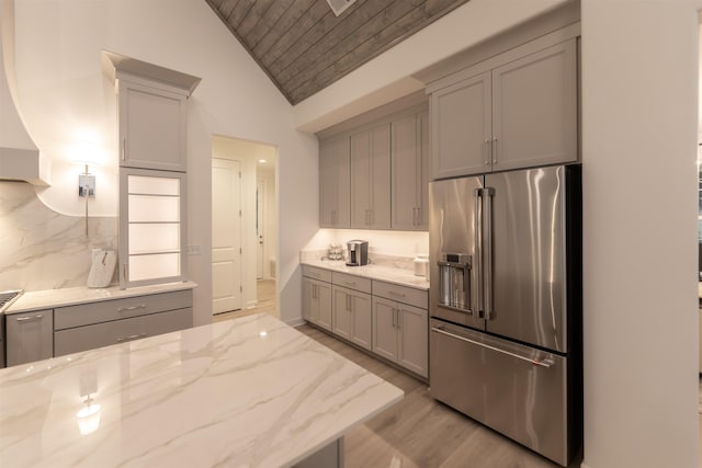 kitchen featuring high end fridge, gray cabinets, wood ceiling, lofted ceiling, and light stone countertops