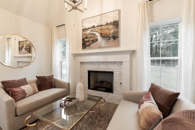 living room with a fireplace, wood finished floors, and a notable chandelier