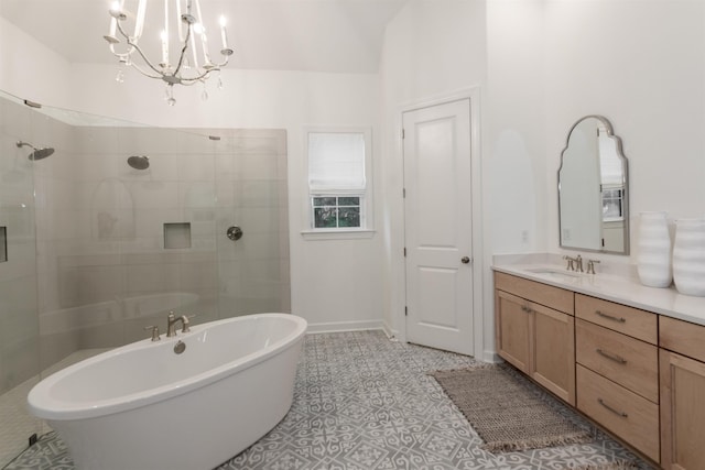 bathroom with vanity, an inviting chandelier, a soaking tub, tile patterned flooring, and tiled shower