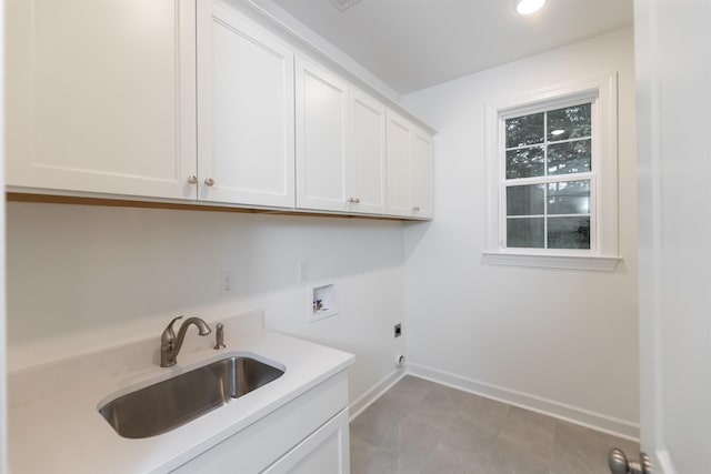 clothes washing area featuring a sink, baseboards, hookup for a washing machine, cabinet space, and electric dryer hookup