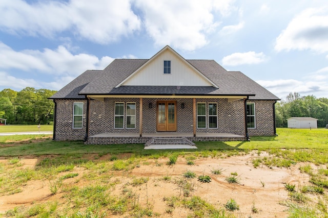 view of front of property with brick siding, french doors, and roof with shingles