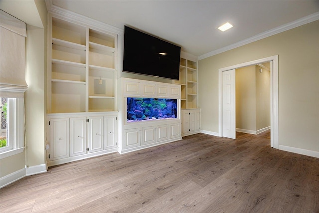 unfurnished living room with wood finished floors, baseboards, and crown molding