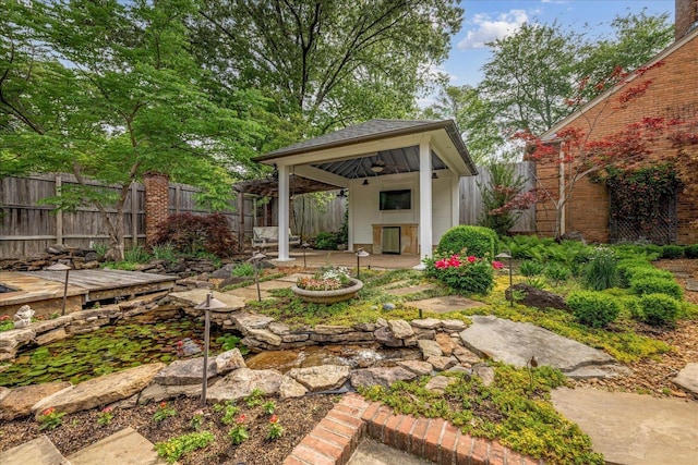 view of yard with a fenced backyard, a gazebo, a ceiling fan, and a patio