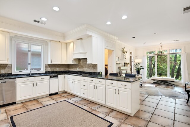 kitchen with stainless steel appliances, backsplash, a sink, a peninsula, and custom exhaust hood