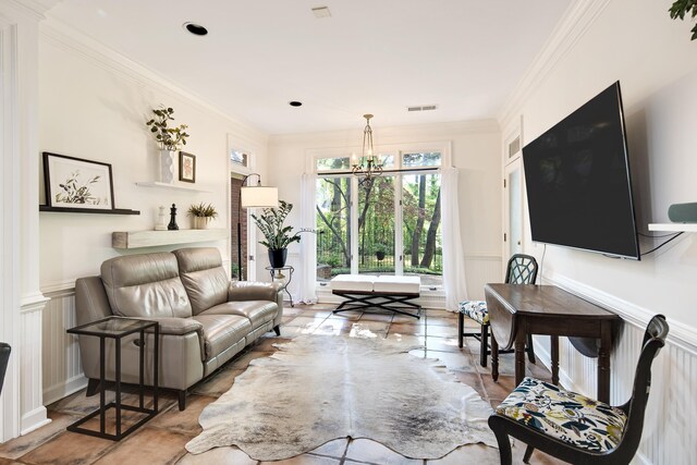 living area with a decorative wall, crown molding, a chandelier, a wainscoted wall, and visible vents