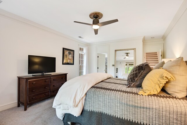 bedroom featuring baseboards, visible vents, light colored carpet, ceiling fan, and crown molding