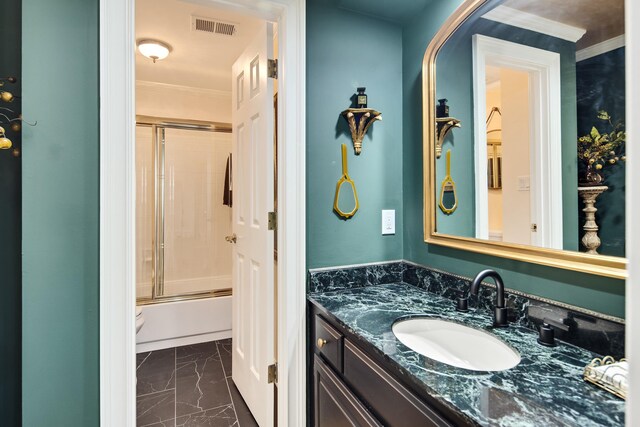 full bathroom featuring shower / bath combination with glass door, marble finish floor, visible vents, vanity, and crown molding