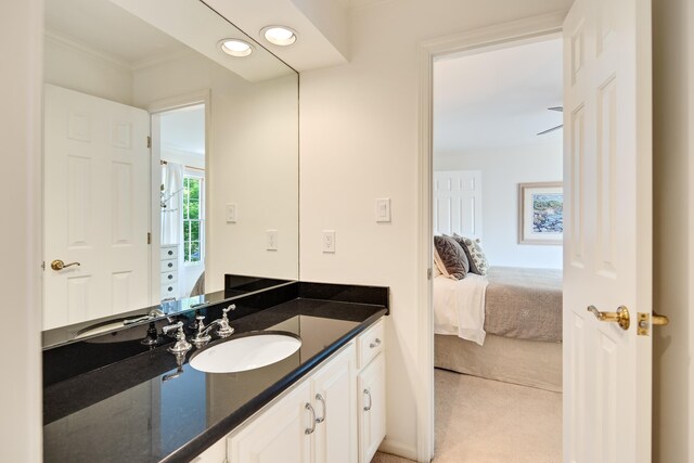ensuite bathroom with connected bathroom, crown molding, vanity, and recessed lighting