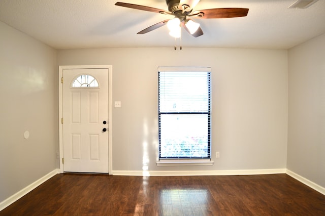 foyer entrance featuring wood finished floors, visible vents, a ceiling fan, and baseboards