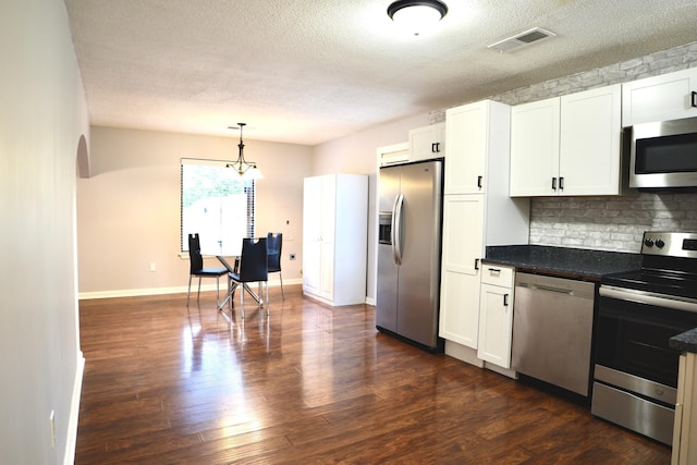 kitchen featuring a textured ceiling, visible vents, decorative backsplash, and stainless steel appliances